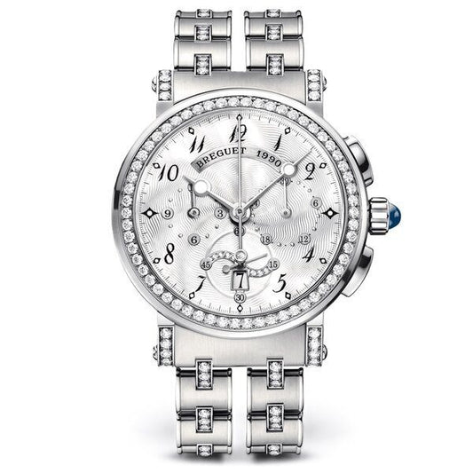 A luxury silver-tone wristwatch with a diamond-encrusted bezel, matching diamond-set bracelet, and a white dial featuring multiple subdials and a day window. The brand name 'BREGUET' is visible on the dial.