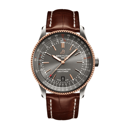 Breitling Navitimer watch with a grey dial, rose gold tone hands and beaded bezel, date window at 6 o’clock and brown leather strap with white stitching.