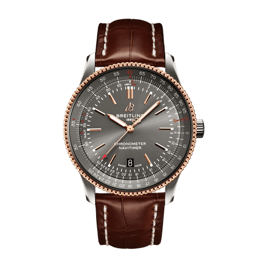 Breitling Navitimer watch with a grey dial, rose gold tone hands and beaded bezel, date window at 6 o’clock and brown leather strap with white stitching.