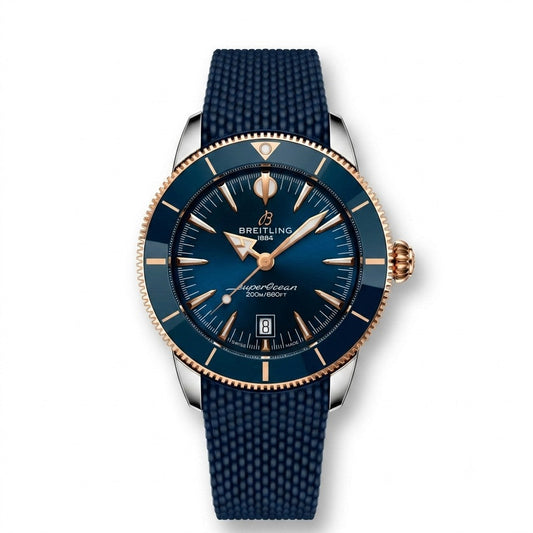 A Breitling Superocean Heritage B31 Automatic 44 wristwatch featuring a two-tone stainless steel and 18k red gold case, a blue ceramic bezel, and a sunburst blue dial with a date window at 6 o'clock, paired with a blue rubber strap.