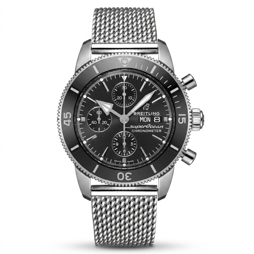Breitling Superocean Heritage luxury chronograph watch featuring a black dial with three subdials, silver-tone hands and hour markers, black rotating bezel, stainless steel case, day-date display, and stainless steel mesh bracelet.