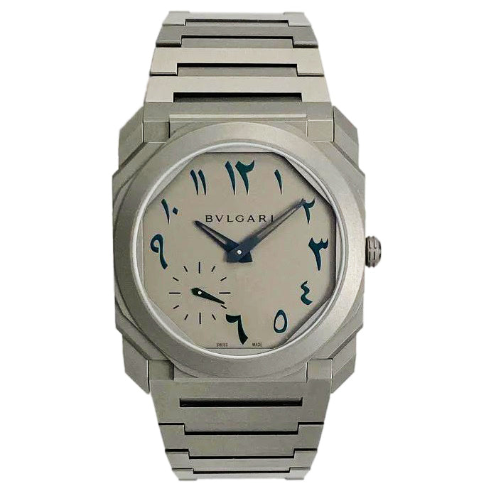 Bvlgari watch with a silver-tone case and bracelet, pale dial with blue Arabic numerals, and a small seconds subdial.