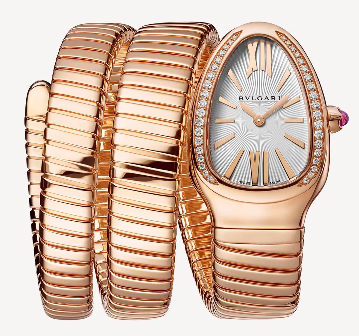 Bvlgari watch with a rose gold-tone spiral bracelet, teardrop-shaped case, silver patterned dial, and stone-set bezel.