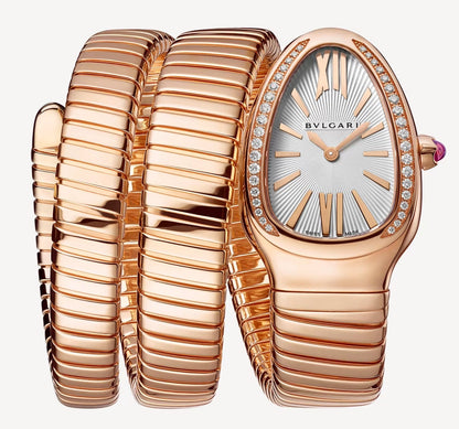 Bvlgari watch with a rose gold-tone spiral bracelet, teardrop-shaped case, silver patterned dial, and stone-set bezel.