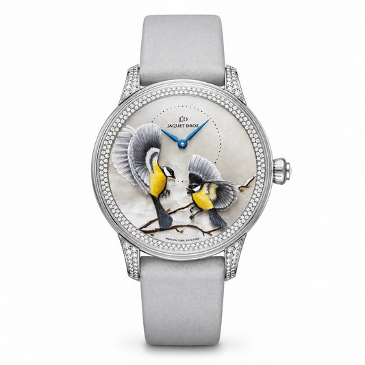 Jaquet Droz watch with a silver-tone case, stone-set bezel, dial depicting two birds on branches, blue hands, and a light grey strap.